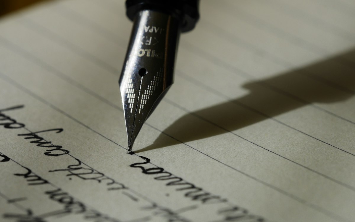 A fountain pen writing in a notebook.