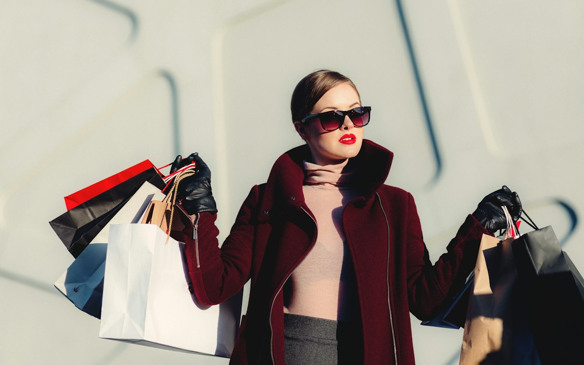A shopper carrying bags outside a store.