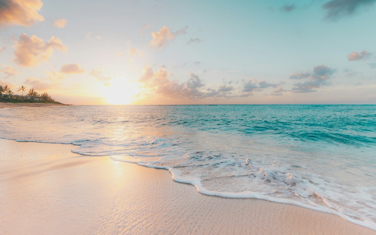 A quiet beach at sunset with gentle waves.