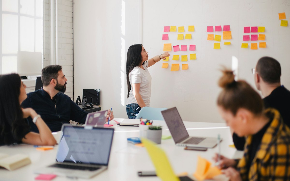 A team comparing ideas on a wall of colorful notes.