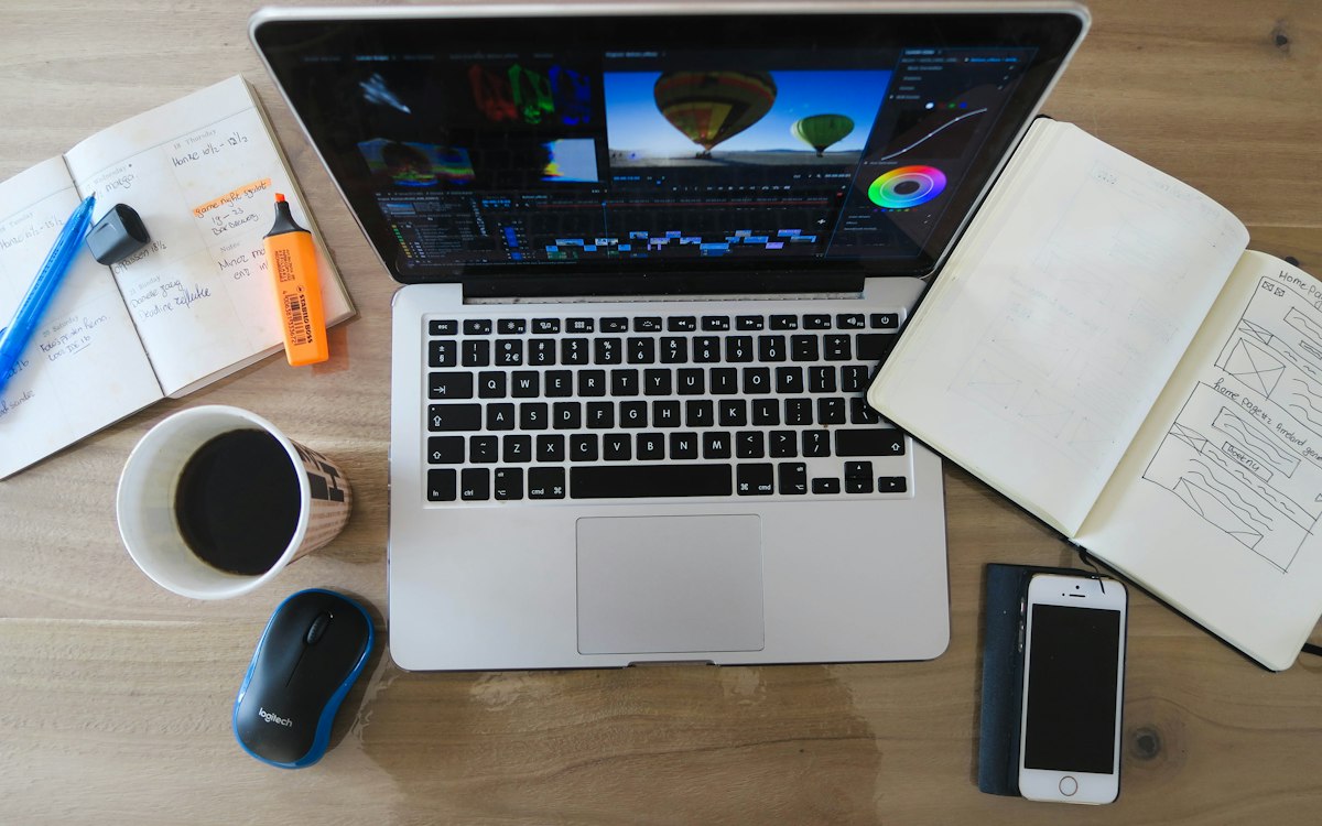 A laptop and research materials arranged on a worktable.