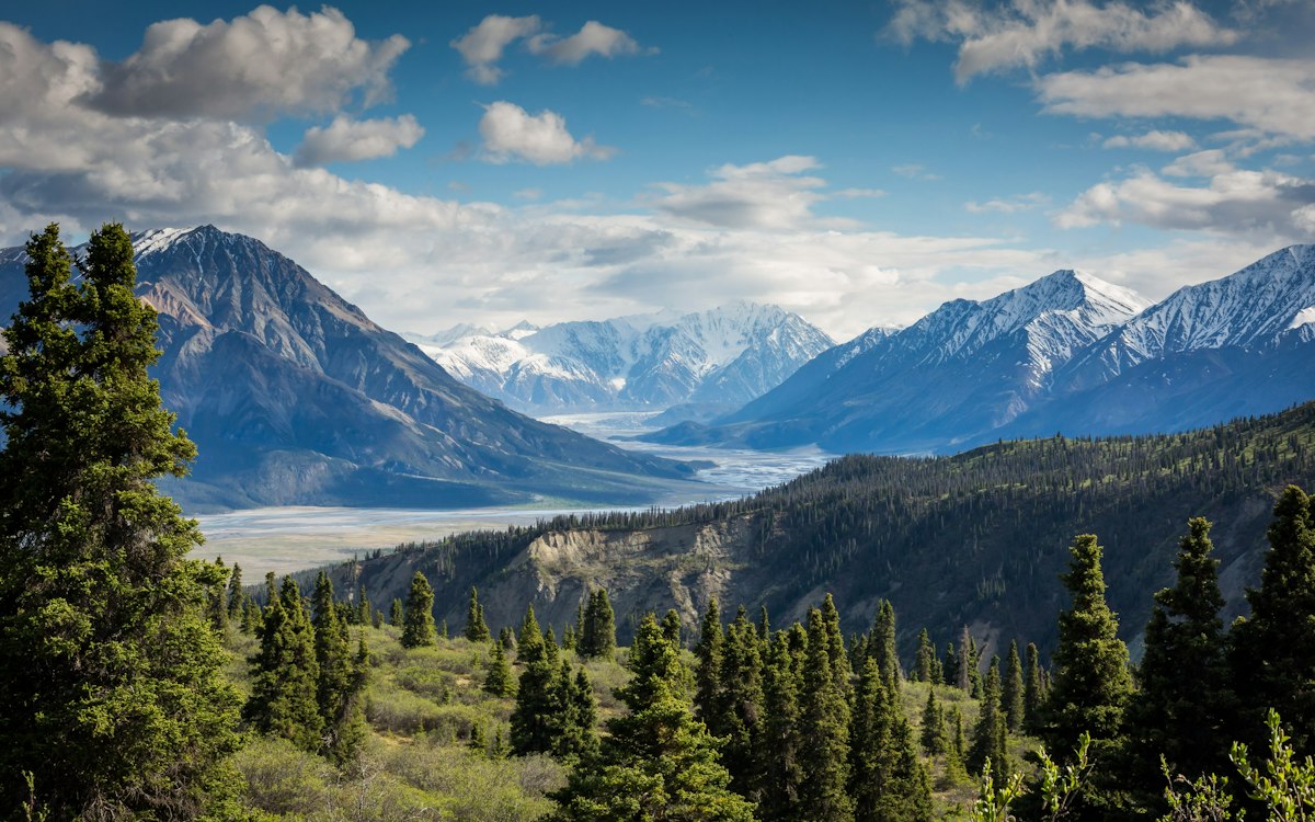 A mountain range rising above a green valley.